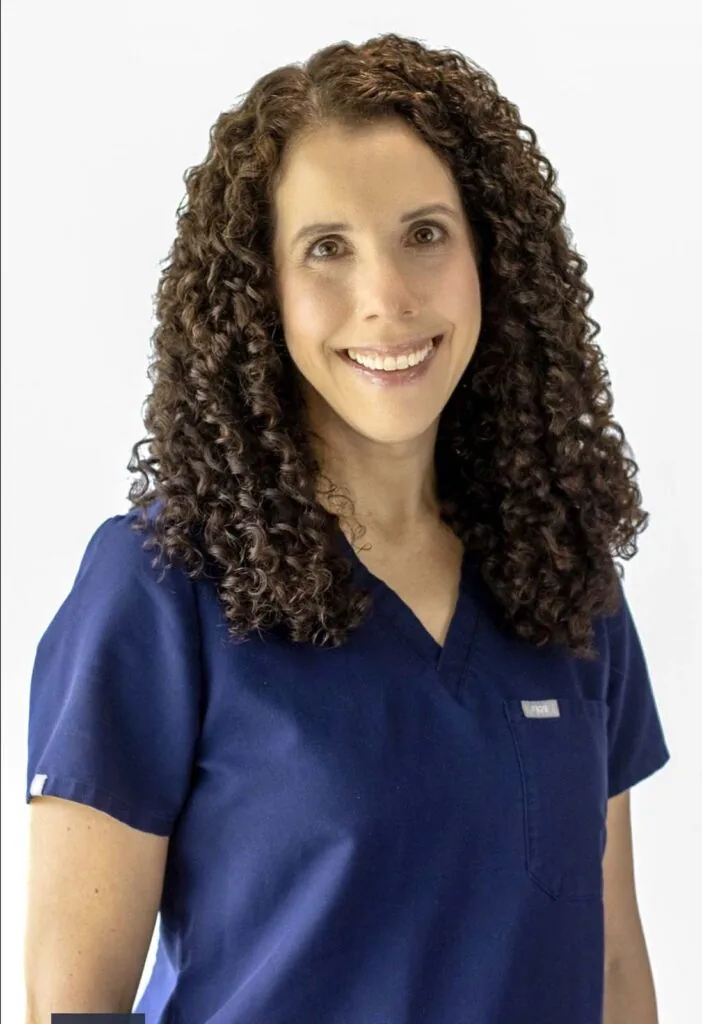 Headshot of Dr. Amanda Hochstein wearing a navy blue scrub and off-white background.